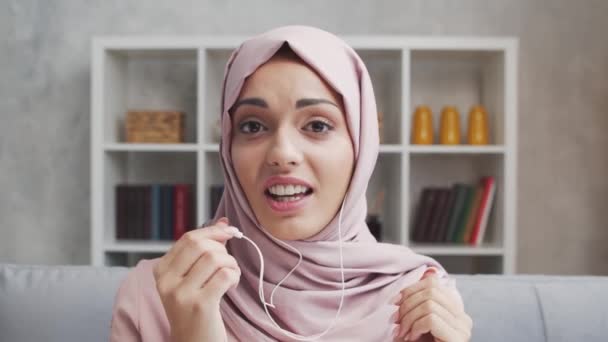 히잡에 매력적 모슬렘 여자는 헤드폰을 사용하여 집에서 중동의 프리랜서나 학생들은 — 비디오