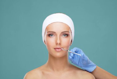 Genç bir kadının güzel yüzüne iğne yapan bir doktor. Estetik ameliyat, cilt gerdirme ve estetik tıp konsepti.
