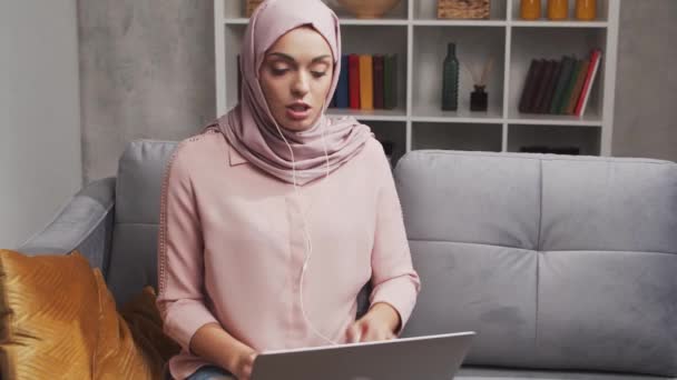 히잡에 매력적 이슬람 여성은 노트북 컴퓨터를 사용하여 집에서 중동의 프리랜서나 — 비디오