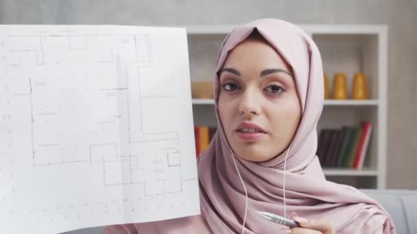 히잡에 매력적 모슬렘 여자는 헤드폰을 사용하여 집에서 중동의 프리랜서나 학생들은 — 비디오