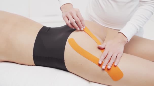 Therapist Applying Kinesio Tape Female Body Physiotherapy Kinesiology Recovery Treatment — Stock Video