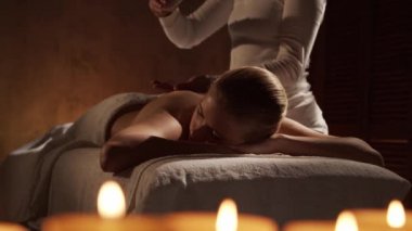 Genç, sağlıklı ve güzel bir kadın spa salonunda masaj terapisi görüyor. Sağlıklı yaşam tarzı ve vücut bakımı kavramı.