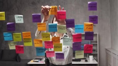 Genç iş kadınının camdaki çıkartmaları kullanarak beyin fırtınası yaptığı zaman dilimi. Ofis çalışanı strateji, iş planı ve hedefleri düşünüyor. Başlangıç konsepti.