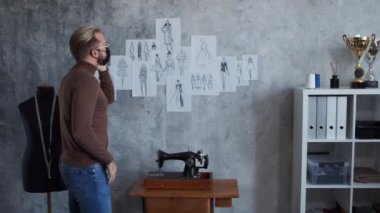 Genç ve yetenekli moda tasarımcılarının işyeri. Terzi şık çatı katında tek başına çalışıyor. Kıyafet çizimleri kullanıyor..