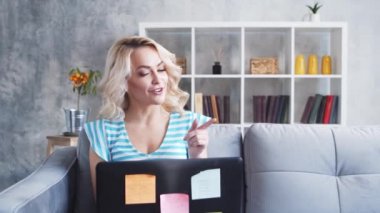 Genç ve çekici bir kadın evde dizüstü bilgisayar kullanarak çalışıyor. Serbest çalışan ya da öğrenci çevrimiçi konuşma yapıyor. Kilitleme kavramı.