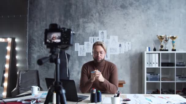 年轻的时尚博客正在用相机记录服装设计的视频博客 他在现代阁楼的工作环境中涌现出一批有才华的造型师 — 图库视频影像