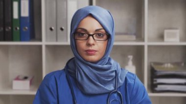 Profesyonel Müslüman tıp doktoru hastane ofisinde çalışıyor. Orta Doğulu genç ve çekici bir kadın doktorun portresi. Tıbbi konsept.