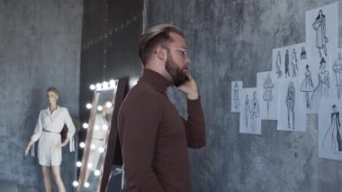 Genç ve yetenekli moda tasarımcılarının işyeri. Terzi şık çatı katında tek başına çalışıyor. Kıyafet çizimleri kullanıyor..