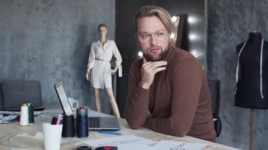 Genç ve yetenekli moda tasarımcılarının işyeri. Terzi şık çatı katında tek başına çalışıyor. Kıyafet çizimleri kullanıyor..