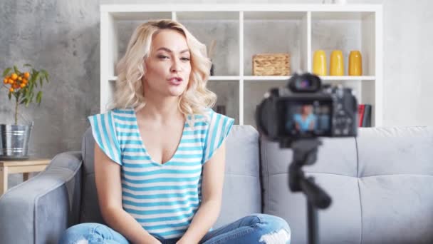 一个年轻貌美的女人正在用摄像机记录视频博客 快乐的女孩正坐在家里咒骂着 — 图库视频影像