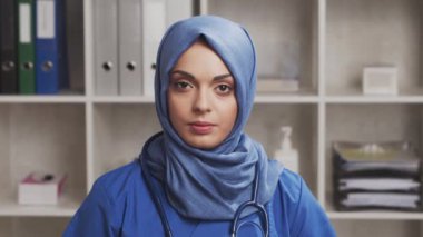 Profesyonel Müslüman tıp doktoru hastane ofisinde çalışıyor. Orta Doğulu genç ve çekici bir kadın doktorun portresi. Tıbbi konsept.