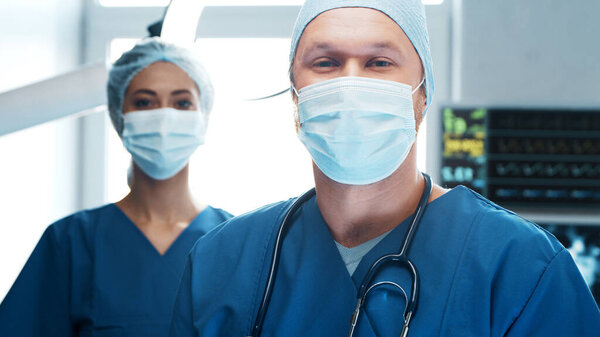 Professional medical doctors working in emergency medicine. Portrait of the surgeon and the nurse in protective masks performing surgical operation. Medical concept.