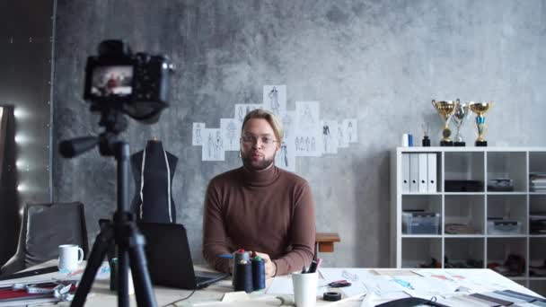 Fiatal divat vlogger rögzíti video vlogabout design ruhák segítségével kamera. Tehetséges stylist patak a munkahelyéről a modern padláson.