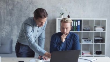 Modern ofiste iki iş adamı birlikte çalışır. İş adamlarından oluşan bir ekip beyin fırtınası yapıyor. Başlangıç ve eşçalışma kavramları.
