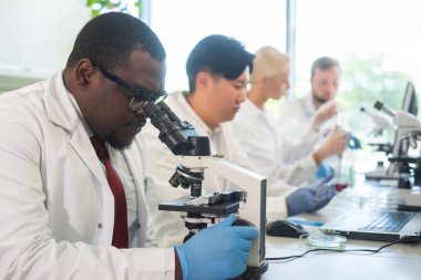 Laboratuvarda çalışan bilim adamları ve öğrenciler. Doktor stajyerlere araştırma yapmayı öğretiyor. Biyoteknoloji, kimya, bakteriyoloji, viroloji, DNA ve sağlık hizmetleri kavramı.