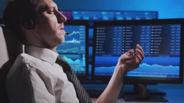 Komisyoncu, çalışma istasyonu ve analiz teknolojisi kullanarak ofiste çalışıyor. Profesyonel tüccarların işyeri. Küresel finans piyasaları, iş dünyası, döviz kurları ve bankacılık kavramları.