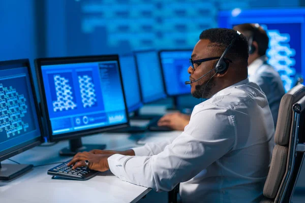 Çağrı merkezi çalışanı müşteriyle kulaklıkla konuşuyor. Afro-Amerikan destek operatörünün işyeri..