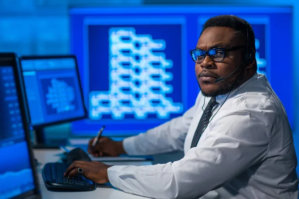 Afro-Amerikaanse makelaar werkt in het kantoor met behulp van werkstation en analyse technologie. Werkplaats van de professionele handelaar. Mondiale financiële markten, bedrijfs-, valutawisselings- en bankconcepten. — Stockfoto