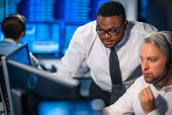 Komisyonculardan oluşan bir ekip, çalışma istasyonu ve analiz teknolojisini kullanarak ofiste çalışıyor. Profesyonel tüccarların işyeri. Küresel finans piyasaları, iş dünyası, döviz kurları ve bankacılık kavramları.