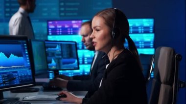 Komisyonculardan oluşan bir ekip, çalışma istasyonu ve analiz teknolojisini kullanarak ofiste çalışıyor. Profesyonel tüccarların işyeri. Küresel finans piyasaları, iş dünyası, döviz kurları ve bankacılık kavramları.