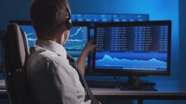Komisyoncu, çalışma istasyonu ve analiz teknolojisi kullanarak ofiste çalışıyor. Profesyonel tüccarların işyeri. Küresel finans piyasaları, iş dünyası, döviz kurları ve bankacılık kavramları.