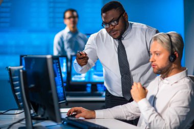 Komisyonculardan oluşan bir ekip, çalışma istasyonu ve analiz teknolojisini kullanarak ofiste çalışıyor. Profesyonel tüccarların işyeri. Küresel finans piyasaları, iş dünyası, döviz kurları ve bankacılık kavramları.