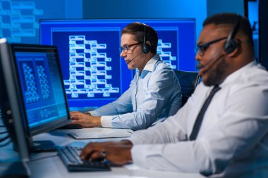 Çağrı merkezi çalışanı müşteriyle kulaklıkla konuşuyor. Afro-Amerikan destek operatörünün işyeri..