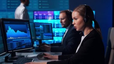 Komisyonculardan oluşan bir ekip, çalışma istasyonu ve analiz teknolojisini kullanarak ofiste çalışıyor. Profesyonel tüccarların işyeri. Küresel finans piyasaları, iş dünyası, döviz kurları ve bankacılık kavramları.