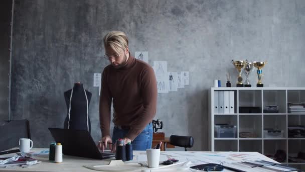 Werkplaats van jonge en getalenteerde modeontwerper. Maatwerk in stijlvol hok met schetsen van kleding. — Stockvideo