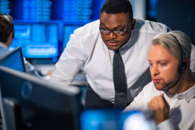 Komisyonculardan oluşan bir ekip, çalışma istasyonu ve analiz teknolojisini kullanarak ofiste çalışıyor. Profesyonel tüccarların işyeri. Küresel finans piyasaları, iş dünyası, döviz kurları ve bankacılık kavramları.