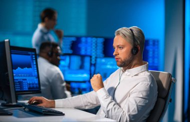 Komisyonculardan oluşan bir ekip, çalışma istasyonu ve analiz teknolojisini kullanarak ofiste çalışıyor. Profesyonel tüccarların işyeri. Küresel finans piyasaları, iş dünyası, döviz kurları ve bankacılık kavramları.