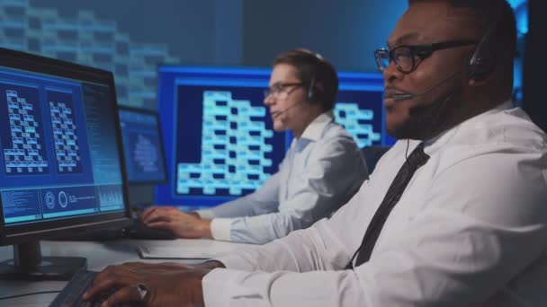 De werknemers van het callcenter spreken met de klanten via de headset. Werkplaats van de professionele ondersteuners. Teamwork concept. — Stockvideo