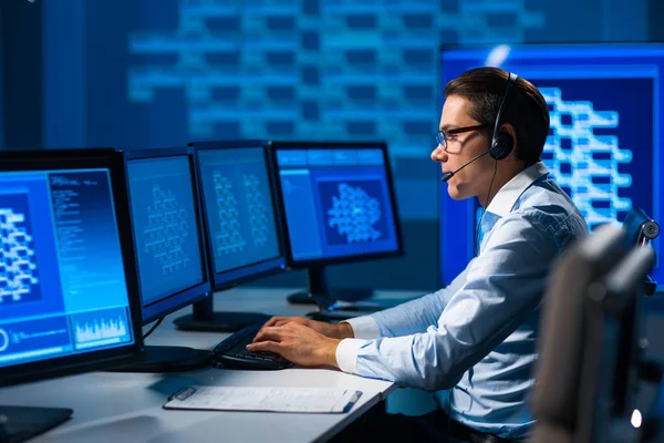 De medewerker van het callcenter spreekt met de klant per headset. Werkplaats van de functionaris voor professionele ondersteuning. — Stockfoto