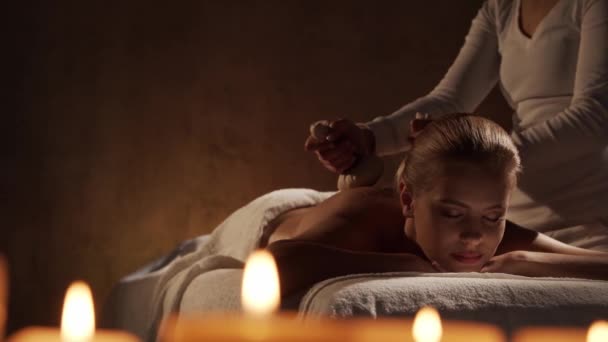 Jonge en mooie vrouw krijgt kruidenbal massage therapie in de spa salon. Gezond levensstijl en lichaamsverzorging concept. — Stockvideo