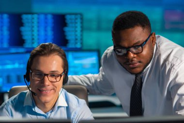 Komisyonculardan oluşan bir ekip, çalışma istasyonu ve analiz teknolojisini kullanarak ofiste çalışıyor. Profesyonel tüccarların işyeri. Küresel finans piyasaları, iş dünyası, döviz kurları ve bankacılık kavramları.