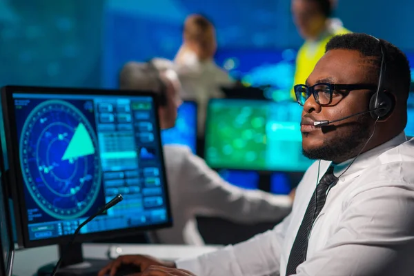 Werkplaats van de luchtverkeersleiders in de verkeerstoren. Een divers team van vliegtuigcontroleurs werkt met radar, computernavigatie en digitale kaarten. Luchtvaartconcept. — Stockfoto