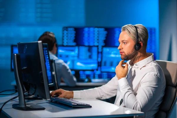 Komisyonculardan oluşan bir ekip, çalışma istasyonu ve analiz teknolojisini kullanarak ofiste çalışıyor. Profesyonel tüccarların işyeri. Küresel finans piyasaları, iş dünyası, döviz kurları ve bankacılık kavramları.