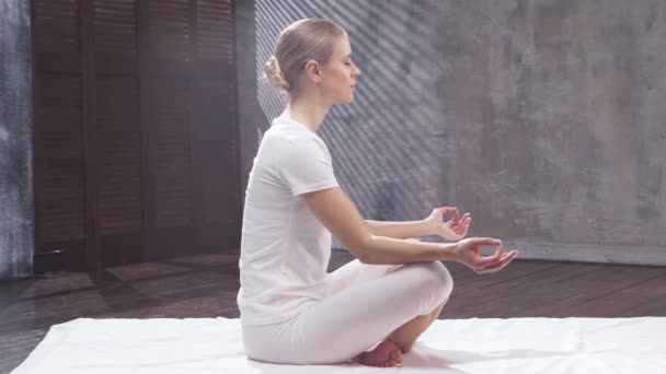 Jeune femme en forme pratique le yoga à l'intérieur de la classe. Exercice d'étirement à la lumière du jour. Sport, conditionnement physique, soins de santé et modes de vie. — Video