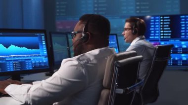 Ofiste çalışan çeşitli simsarlar çalışma istasyonu ve analiz teknolojisi kullanıyor. Profesyonel tüccarların işyeri. Küresel finans piyasaları, iş dünyası, döviz kurları ve bankacılık kavramları.