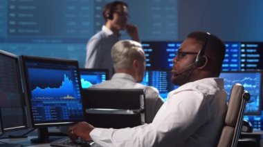 Ofiste çalışan çeşitli simsarlar çalışma istasyonu ve analiz teknolojisi kullanıyor. Profesyonel tüccarların işyeri. Küresel finans piyasaları, iş dünyası, döviz kurları ve bankacılık kavramları.