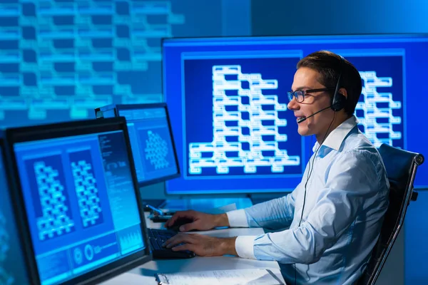 Le préposé du centre d'appels parle avec le client par casque. Lieu de travail de l'opérateur de soutien professionnel au bureau. — Photo