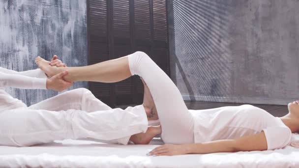 Jovem está recebendo tratamento de massagem tailandesa pelo terapeuta. Terapia tradicional de alongamento asiático. — Vídeo de Stock