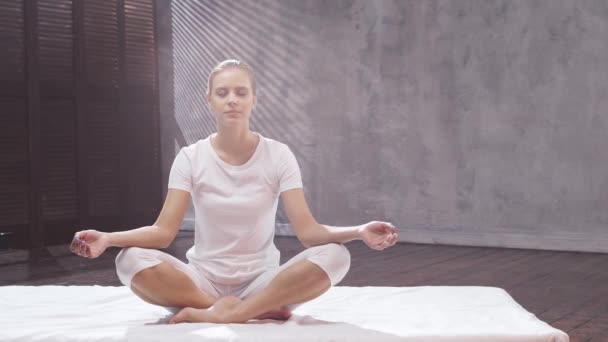 Jeune femme en forme pratique le yoga à l'intérieur de la classe. Exercice d'étirement à la lumière du jour. Sport, conditionnement physique, soins de santé et modes de vie. — Video