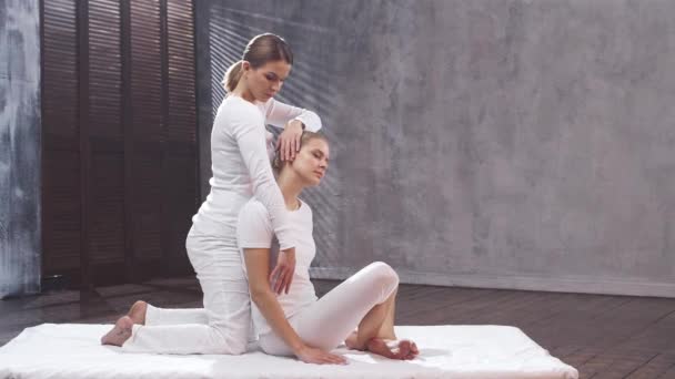 Młoda kobieta przechodzi tajski masaż przez terapeutę. Tradycyjna azjatycka terapia rozciągająca. — Wideo stockowe