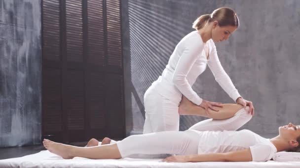 Молодая женщина получает Тайский массаж лечение терапевта. Традиционная азиатская растяжка. — стоковое видео