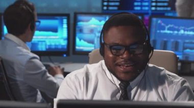 Ofiste çalışan çeşitli simsarlar çalışma istasyonu ve analiz teknolojisi kullanıyor. Profesyonel tüccarların işyeri. Küresel finans piyasaları, iş dünyası, döviz kurları ve bankacılık kavramları.