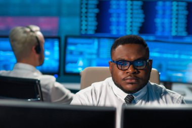 Komisyonculardan oluşan bir ekip, çalışma istasyonu ve analiz teknolojisini kullanarak ofiste çalışıyor. Profesyonel tüccarların işyeri. Küresel finans piyasaları, iş dünyası, döviz kurları ve bankacılık kavramları.