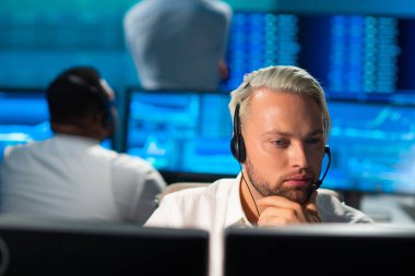 Komisyonculardan oluşan bir ekip, çalışma istasyonu ve analiz teknolojisini kullanarak ofiste çalışıyor. Profesyonel tüccarların işyeri. Küresel finans piyasaları, iş dünyası, döviz kurları ve bankacılık kavramları.