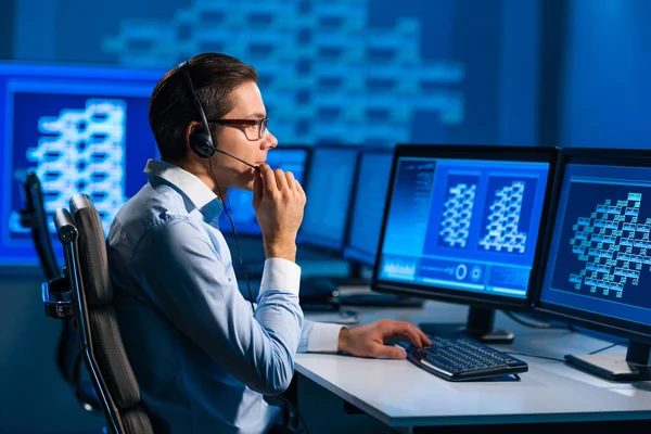 El trabajador del centro de llamadas está hablando con el cliente por auriculares. Lugar de trabajo del operador de apoyo profesional en el cargo. —  Fotos de Stock
