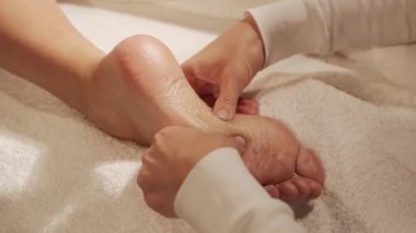 Genç ve güzel bir kadın spa salonunda topuklu masaj terapisi görüyor. Sağlıklı yaşam tarzı ve vücut bakımı kavramı.